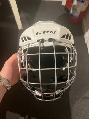 Hockeyhjälm - Vit hockeyhjälm från CCM med galler, modell FL40 i storlek L barn. 