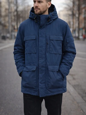 Carhartt herr strl M vinterjacka med huva parkas - Säljer en mörkblå parkas från Carhartt med huva strl M. Flera stora fickor framtill. Jackan har snygga detaljer som metallknappar med logga och dragsko vid halsen. Lite slitage på knappar. Använt fint skick. 