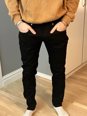 Svarta byxor från 157 i storlek L - Svarta byxor från 157 i storlek L. De har en slim passform med raka ben och klassisk femficksdesign. Byxorna är tillverkade i ett mjukt bomullsmaterial med lite stretch för extra komfort. Perfekta för dig som gillar en stilren och enkel look.