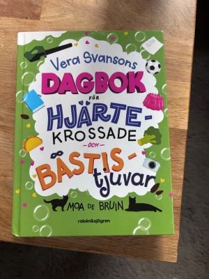 Vera Svansons dagbok för hjärtekrossade och bästistjuvar - En rolig och färgstark dagbok om Vera och hennes galna familj, kärlek, vänskap och vardagsdrama. Perfekt för dig som gillar humor, pinsamma situationer och att läsa om livet som ung! Boken är tredje delen om Vera Svanson och passar dig som vill ha lättläst och underhållande läsning. Bra ålder 10-13