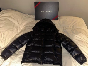 Ralph Lauren - The Gorham Glossed Down  - Tjena! Säljer nu min vinterjacka från Ralph Lauren!! Ett fruktansvärt bra skick på jackan till ett bra pris. Skick 9/10. Använts ett fåtal gånger förra vintern men inget mer än det. Kvittens på jackan finns om det önskas att se. Hör av er vid intresse eller minsta lilla fråga. Pris går att diskuteras vid snabb affär. Ha det bäst så länge! :) 