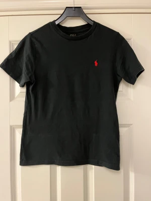 Svart t-shirt från Polo Ralph Lauren - Snygg svart t-shirt från Polo Ralph Lauren med rött polo märke. 