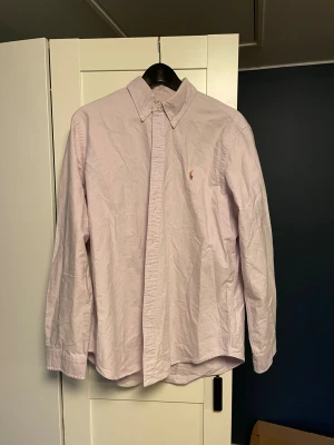 Ljusrosa skjorta från Polo Ralph Lauren - Säljer en stilren ljusrosa skjorta från Polo Ralph Lauren. Priset går att diskutera kan gå ner väldigt mycket vid snabb affär 