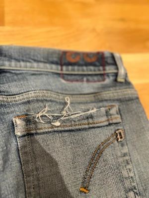 Dondup George med slitningar - Säljer ett par blå jeans från Dondup med snygga slitningar och trasiga detaljer på både o bak. Storleken är 33 men passar någon som är typ 173-183. Storlek 33 motsvarar typ waist 30-31. Det är väldigt bra skick och alla slitningar är bara detalj. Hör av dig om mer frågor. Priset är prutbart via enkel affär!