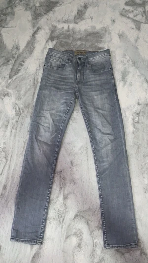Gråa slim fit jeans  - Säljer ett par gråa slim fit jeans just för att jag vuxit ur storleken. Annars ett väldigt fint par med en stilren grå färg på jeansen som sitter perfekt med inprincip allt.