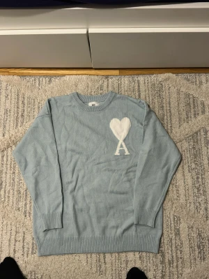 Ami paris blå - Helt ny ami paris tröja med färgen ljus blå som är stillig och unik. Den passar i många outfit och inte många som har denna tröjan