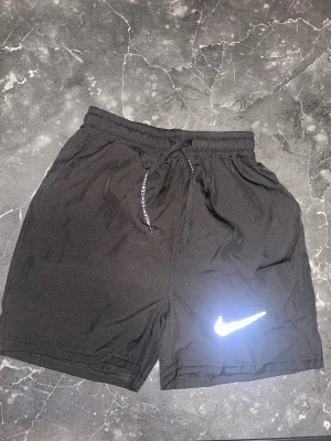 Svarta Nike träningsshorts - Svarta Nike träningsshorts som även kan fungera som vanliga shorts. Shortsen är i storlek XS men passar även S. Shortsen är aldrig använda. Shortsen har även fickor. Fler bilder kan skickas och pris kan diskuteras. 