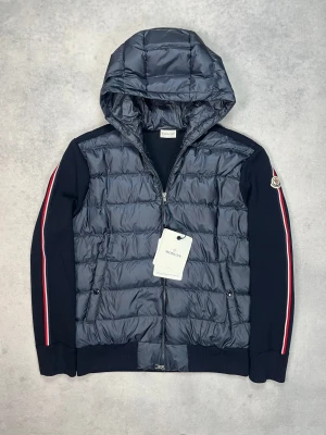 Moncler hooded cardigan jacket - – Condition: 10/10 - brand new with tags  - Size: XL  – Retail price: 10 000 + SEK  Please note that Moncler runs small, we recommend going up one size from your usual size.