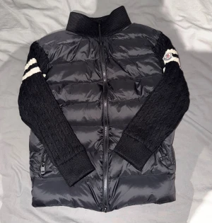 Moncler dun/cardigan XS – helt ny - Superfin Moncler cardigan-jacka i storlek XS. Den är ganska liten i passformen, så den passar bäst om du brukar ha XXS–XS. Jackan är helt oanvänd och i perfekt skick.  Dunfront och rygg i hög kvalité, samt stickade ärmar med Moncler-loggan på ena armen. Väldigt mjuk, varm och skön – en riktigt snygg och lyxig modell som funkar både som jacka och mellanlag. NFC märke finns!