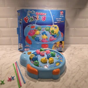 GOGO! Fishing NO.366 - Roligt elektroniskt fiskespel för barn med färgglada fiskar och tre fiskespön. Spelbrädan kan fyllas med vatten för extra realism. Passar för 3+ år och upp till 3 spelare. Produkten ser ut att vara i mycket gott skick utan synligt slitage. Själva paketet har mindre skador från förvaringen. 