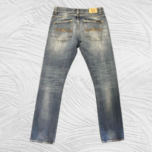 Nudie Jeans Vintage/Sällsynta - Nudie Jeans Dude Dan (W31 L32) Sällsynta vintagejeans från Nudie, i klassisk Dude Dan-passform – rak och tidlös modell med perfekt vintagetvätt. Autentisk denimkänsla med subtila slitningar och riktigt snygg blå ton 2000 tals kännsla!!! Jeansen är i mycket bra skick, inga hål eller fläckar.