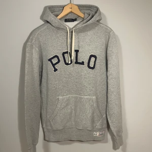 Grå Ralph Lauren Hoodie  - Snygg hoodie från Ralph Lauren med eftertraktat motiv. Storlek S. Väldigt fint skick, härlig och mjuk hoodie. Kan lösa gratis frakt på denna tröjan. Hör gärna av er vid funderingar!🙌🏻