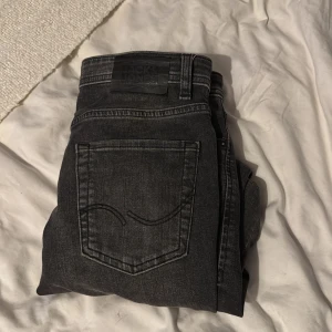 Svarta slim jeans från Jack & Jones - Svarta jeans från Jack & Jones i slim fit-modell. Perfekta för dig som gillar en stilren och modern vibe. Storlek 158/13y men sitter som 27-28/30