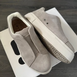 Beige mockasneakers från Eytys - Snygga sneakers från Eytys i beige mocka med chunky vit sula och elastisk detalj framtill istället för snörning. Skorna har en diskret lila detalj bak på hälen och en stilren, minimalistisk design. Perfekta för dig som gillar cleana och trendiga sneakers. Skriv vid frågor!☺️