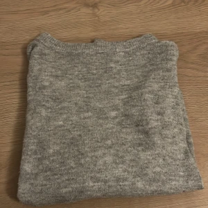 Grå stickad tröja - Mysig grå stickad tröja med rund hals från Lager 157. Tröjan har inte används mycket och är i mycket gott skick.