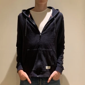 T&H Zip-Tröja - En snygg o enkel zip tröja med luva från Tommy Hilfigher som funkar för alla tillfällen. Tröjan har varit flitigt använd men utan tecken. Därför lågt pris. Strl M men sitter mer som S