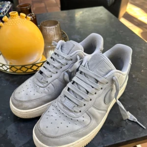Nike Air Force 1  - Säljer ett par Nike Air Force 1 i snygg ljusgrå mocka. Jättesköna att gå i, mjuk och skön sula. Storlek 38. Hör av er vid fler frågor!