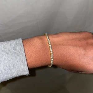 Tennischain armband guld  - Helt ny. Fin replika med grym kvalitet. Elastiskt armband. Pris 120kr. Först till kvarn som gäller.
