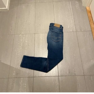 Replay jeans  - Säljer ett par replay jeans i klassisk blå tvätt. Jeansen har en slim passform med raka ben och snygga slitningar framtill. 