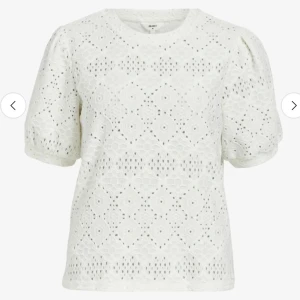 Vit spetsblus från Object - Superfin vit blus från Object med broderade detaljer och korta puffärmar. Blusen har rund halsringning och är tillverkad i bomull med spetsmönster som ger en romantisk vibe. Perfekt för dig som gillar en söt och stilren look.