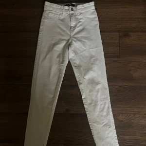 Vita skinny jeans - Snygga vita jeans från Bik Bok i storlek XS. Modellen är skinny med hög midja och klassiska fem fickor. Byxorna har bälteshällor och stängs med knapp och dragkedja. Perfekta för en fräsch och stilren look.