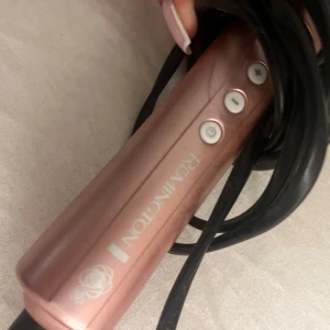 Remington Rose Gold Curling Wand - Remington locktång i roséguld med digitala temperaturinställningar och keramisk konisk stav. Sladd och kontakt i gott skick, inga synliga repor eller skador. Perfekt för att skapa mjuka lockar och vågor. Enkel att använda med snabb uppvärmning.