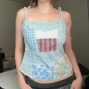  denim korsettopp med knytband - Säljer en unik jeanskorsett med patchwork-design i olika mönster och färger. Toppen har smala axelband som knyts och en dragkedja i sidan. Jag på bilden har strl 36 på överdelar och är 170cm lång. Klicka på köp nu <<33
