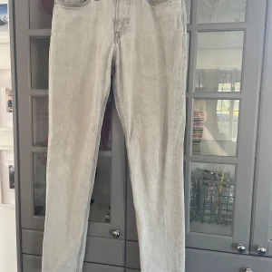 Grå tapered jeans från H&M 28/32 - Grå jeans från H&M i modellen Regular Tapered med relaxed passform och justerbar midja. Klassisk femficksdesign och raka ben som smalnar av nedtill. Tillverkade i mjukt jeanstyg, perfekta för en chill och stilren look.
