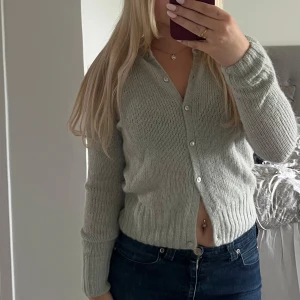Ljusgrå stickad kofta Zara - Supermysig ljusgrå stickad kofta med v-ringning och knappar framtill. 