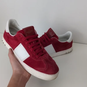 Valentino skor  -  [Alla nitar kvar 🤩🌴]. Tjosan! Säljer dessa sjukt snygga röda Valentino flycrews i röd mocka färg! Denna modell säljs ej längre. || Nypris ≈8000kr ❌. Vårt pris=3499kr ✅|| storlek: 42 passar 43.  skick: 10/10 🤩, säljer billigt pga en liten skada som ni ser på bild "4" 😁. Självklart äkta! ✅. Endast skor och Valentino kort medföljer via köp, jag tycker priser är dunder men här av er! 🌴🐥