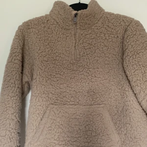 Beige teddy tröja💕 - Mysig beige Teddy -tröja med halv dragkedja och stor känguruficka framtill. Tröjan har hög krage och är perfekt för kyliga dagar. Den fluffiga ytan ger en riktigt skön och avslappnad vibe.