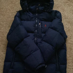 Mörkblå Polo Ralph lauren jacka  - Tja säljer min gamla vinter jacka från polo Ralph lauren, den har en deffekt vid fickan vid bröstet men inget någon märker, pris kan diskuteras, STORLEK L men passar som M. 1•1