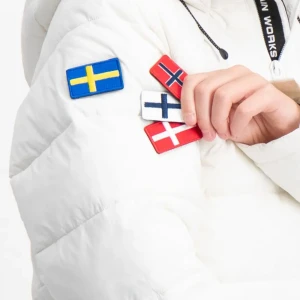 Vit pufferjacka från Mountain Works - Snygg vit pufferjacka från Mountain Works med svensk flagga på ärmen och utbytbara flaggpatches. Jackan har huva, dragkedja framtill och coola svarta detaljer. Perfekt för kalla dagar när du vill sticka ut med stil.Nypris var 2400 säljes för 500