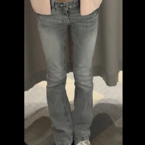Grå bootcut jeans från Gina Tricot - Snygga lågmidjade, gråa jeans från Gina Young i bootcut-modell med coola kontrastsömmar på bakfickorna. Jeansen har klassisk femficksdesign, normal passform och är tillverkade i mjukt denimtyg. Perfekta för dig som gillar en avslappnad men trendig look.