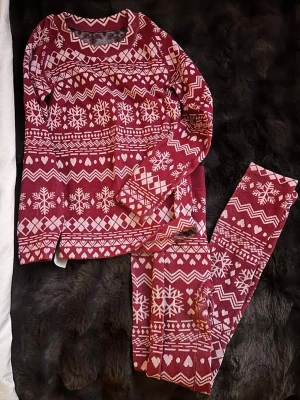 Röd jultröja och byxor med snöflingor och hjärtan från rusta - Mysig röd långärmad tröja och byxor med vitt vintermönster av snöflingor, hjärtan och zigzag. Säljer dom tillsammans skriv i dm ifall frågor eller om förslag på att bara köpa en av dom, dom är endast andvända 1 gång när jag testade dom❤️