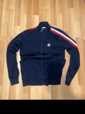 Moncler zip tröja - Väldigt bra skick, mörkblå färg med röda och vita detaljer, storlek s men kan också passa större.