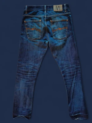 Nudie jeans grim tim dry selvage  - Tjenare! Jag säljer dessa snygga nudies i dry selvage. Dessa jeans är sjukt snygga och har fadeats ganska mycket. Trots ganska hård användning är jeansen i bra skick, det ända som går att anmärka på är att de är slitna vid ankeln då förra ägaren klippt dessa (be om bild, fick ej plats i annonsen)samt lite slitage eftersom de varit cuffade (se bild). Detta går dock att laga hos nudie helt gratis.  Hör av er om ni har fler frågor! Pris kan diskuteras inom viss mån✅️