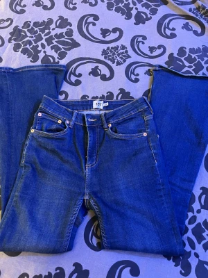 Blå Snake Flare jeans från 157 - Snygga blå jeans från 157 med modellen Snake Flare. Klassisk femficksdesign, kontrastsömmar och utsvängda ben som ger en cool retrovibe. Jeansen är tillverkade i jeansmaterial och har en midjehöjd som känns normal. Perfekt för dig som gillar flare och vill sticka ut.