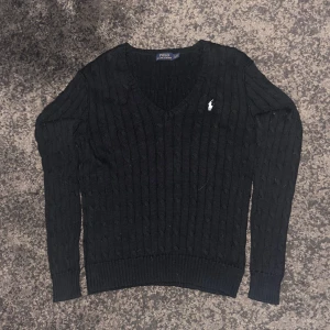 Kabelstickad Ralph Lauren tröja - Säljer denna marinblå kabelstickade Ralph Lauren tröjan. Storlek L och väldigt bra skick. Skicka ett PM om du har några frågor eller vill ha mer bilder.