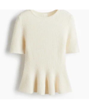 Ribbad vit stickad topp med volang - Supersöt ribbad topp i stickat material, ljusvit färg och korta ärmar. Den har en rund halsringning och en volangkant nedtill som ger en extra touch. Perfekt för dig som gillar en feminin och trendig look. Använd 2 gånger 