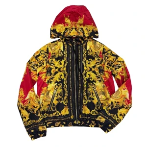 Versace Jeans Couture vindjacka  - Säljer en Versace Jeans Couture vindjacka med ikoniskt barockmönster i guld och svart, samt röda detaljer. Jackan har huva, två fickor med dragkedja och snygga snörningar. Materialet är lätt polyester och jackan har en stor rund dragkedja framtill med Versace-logga. Storlek IT:40 vilket motsvarar S. Retail: 4800 kr. Äkthetskontroll kan man göra på själva hemsidan och använda koden som finns i jackans lappar (CLG) OBS! PRIS GÅR ATT DISKUTERA.