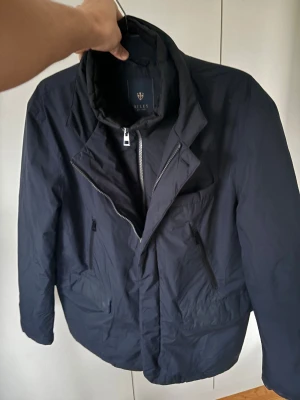 Riley jacka  - Denna jättefina marinblå högkvalitativa dunjackan från Riley säljes i storlek L. Ett riktigt kap, (mycket jacka för pengarna). Toppenskick då den är använd sparsamt. Brutalt snygg och varm vinterjacka som är helt perfekt nu till kallare väder. Tveka inte vid minsta fråga eller fundering🤩