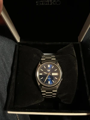 Seiko 5 snxs77 - Säljer nu min Seiko 5 pågrund av att den inte används. Den är i fint skick och sparsamt använd. Nu pris på 2200. Den är automatisk vilket betyder att man inte behöver några batterier. Länkar och redskap för storleks byte med följer.  Har även kvitto på klockan. Om du har några frågor är det bara att höra av sig🙂