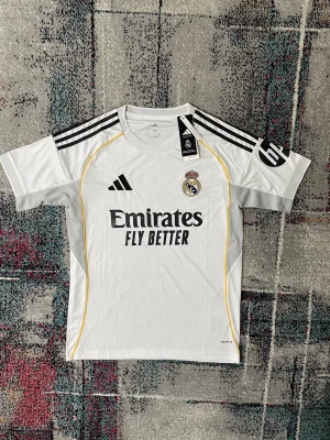 Real Madrid 25/26 Tröja - Säljer denna riktigt snygga tröjan för ett perfekt pris! Skriv till om ni ör intresserade eller har funderingar kring tröjan.