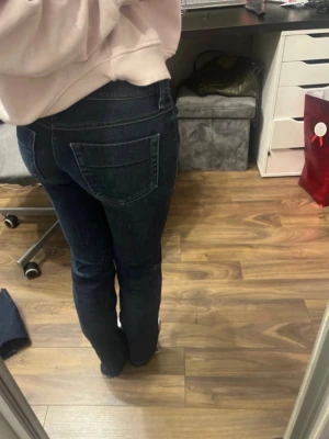 Mörkblå jeans från Diesel - Snygga mörkblå jeans från Diesel med klassisk femficksdesign och kontrastsömmar. Jeansen har en straight passform och är tillverkade i slitstarkt denim med coola detaljer som Diesel Industry-märke på myntfickan. Perfekt för dig som gillar street och casual. Är lite slitna i vissa ställen men märks inte av när de sitter på 