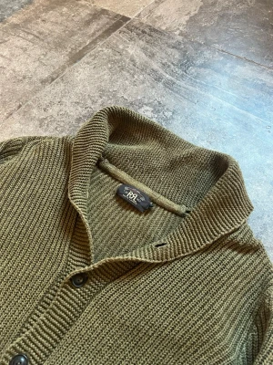 Double RL Stickad Cardigan - heeeelt störd RRL cardigan, kvaliten på denna är otroligt och bekvämligheten likaså👏 storlek L men sitter som M🫡 tveka inte på att skriva ifall du har fler frågor✌️