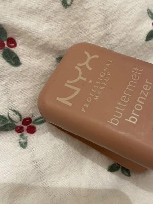 NYX buttermelt bronzer - Endast testad en gång varsamt. Säljer en NYX buttermelt bronzer. Bronzer har en varm, gyllenbrun ton med lätt skimrig finish och en slät, pressad yta. Perfekt för att ge ansiktet en solkysst look och definiera dina drag.