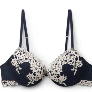 Svart bh med spetsdetaljer - Elegant marinblå bh med vackra vita spetsdetaljer i blommönster. Den har justerbara axelband och en fin spetskant nedtill. Perfekt för att känna sig extra fin under kläderna. Jag säljer denna pågrund av att den är för stor i banden för mig och kommer derför inte till användning💕inte helt säker på storleken men tror det är 75A