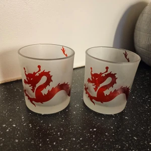 Frostade ljuskoppar med rött drakmotiv - Två coola frostad ljuskoppar med ett rött drakmotiv som slingrar sig runt glaset. Perfekta för att ge en unik touch till ditt kök eller som en present till någon som älskar drakar. 