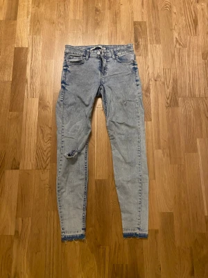 Bershka super skinny jeans ljusblå strl S - Säljer ett par ljusblå super skinny jeans från Bershka med låg midja i strl S. Jeansen har slitna detaljer vid benslut och ett hål på ena benet. Passar fint med boots!!